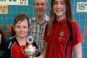 Wisbech Red captains Oscar Smithee (left) and Esme Gilbert accepted the Patterns TransportTrophy from Wisbech Swimming Club vice-chairman Paul Eden. Picture: SIMON GILBERT