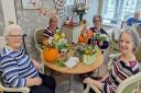 Residents and loved ones enjoying the pumpkin flower arranging session at Hickathrift House care home.