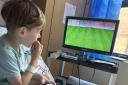 Hunter Martin, aged six, watches football in his hospital room