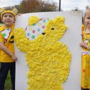 Pupils from Peckover Primary School in Wisbech with a giant Pudsey bear which they created using one and two pence coins.