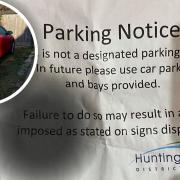 Penny Whitwell was landed with a parking notice, which Huntingdonshire District Council said it does not recognise, for parking in her usual place (inset).
