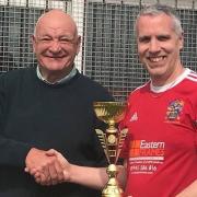 Wisbech Town walking football team captain Richard Mellor with the trophy.